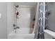 White tiled shower/tub combination with shower caddy and patterned shower curtain at 1810 E Palm Ave # 5114, Tampa, FL 33605