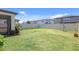 Spacious backyard featuring a lush lawn, vibrant landscaping, and a privacy fence at 1949 Parterre Ave, Lutz, FL 33558