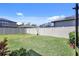 Green backyard with manicured lawn, a white fence, and lush landscaping at 1949 Parterre Ave, Lutz, FL 33558