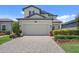 Two-story home featuring a paved driveway leading to an attached two-car garage and landscaped yard at 1949 Parterre Ave, Lutz, FL 33558