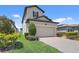 Two-story home featuring a paved driveway leading to an attached two-car garage and landscaped yard at 1949 Parterre Ave, Lutz, FL 33558