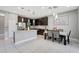 Open kitchen with granite countertops, stainless steel appliances, dining area and dark cabinetry at 1949 Parterre Ave, Lutz, FL 33558