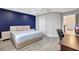 Spacious main bedroom with a blue accent wall, a comfortable bed, and ample natural light at 1949 Parterre Ave, Lutz, FL 33558