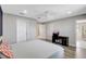A well-lit main bedroom featuring a ceiling fan, a desk, and access to a bathroom at 1949 Parterre Ave, Lutz, FL 33558