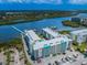 Aerial view of condos with a pool and a dock, nestled in a lush landscape with beautiful water views at 19531 Gulf Blvd # 604, Indian Shores, FL 33785