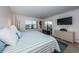 Nicely decorated bedroom with tiled flooring, TV, and sliding glass door to balcony at 19531 Gulf Blvd # 604, Indian Shores, FL 33785