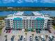 Stunning exterior shot of the condos showcasing the manicured landscape, parking, and the building's colorful accents at 19531 Gulf Blvd # 604, Indian Shores, FL 33785