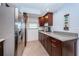 Kitchen features stainless steel refrigerator and granite countertops with stylish wood cabinetry at 19531 Gulf Blvd # 604, Indian Shores, FL 33785
