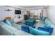 Spacious living room features a large sectional sofa, TV, and sliding glass doors to the balcony at 19531 Gulf Blvd # 604, Indian Shores, FL 33785