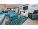 Open concept living room with kitchen in background, large sectional sofa, ottoman, and television at 19531 Gulf Blvd # 604, Indian Shores, FL 33785