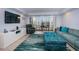 Relaxing living room with large sectional sofa, television, and slider doors to outside balcony at 19531 Gulf Blvd # 604, Indian Shores, FL 33785