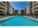 Stunning view of the community pool between the buildings, complete with many lounge chairs around the perimeter at 19531 Gulf Blvd # 604, Indian Shores, FL 33785