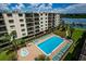 Relaxing pool area with plenty of lounge chairs, set amongst a beautiful and green tropical landscape at 19531 Gulf Blvd # 604, Indian Shores, FL 33785