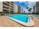 Large in-ground community swimming pool surrounded by lounge chairs and multistory condo buildings under blue skies at 19531 Gulf Blvd # 604, Indian Shores, FL 33785