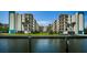 Picturesque water view of condominium buildings surrounded by lush landscaping and serene waterside at 19531 Gulf Blvd # 604, Indian Shores, FL 33785