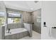Modern bathroom featuring a soaking tub and rainfall shower head at 24405 Summer Wind Ct, Lutz, FL 33559
