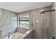 Modern bathroom featuring a soaking tub, rainfall shower head, and backyard view at 24405 Summer Wind Ct, Lutz, FL 33559