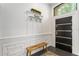Foyer with wainscoting, wooden bench, coat rack, and modern front door at 24405 Summer Wind Ct, Lutz, FL 33559