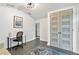Home office with modern desk, stylish rug, and frosted-window doors at 24405 Summer Wind Ct, Lutz, FL 33559