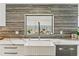 Close-up of the kitchen sink area, showcasing a farmhouse sink, marble counters, and decorative backsplash at 24405 Summer Wind Ct, Lutz, FL 33559