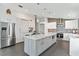 Open kitchen with island, stainless steel appliances, and modern white cabinetry at 24405 Summer Wind Ct, Lutz, FL 33559