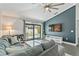 Cozy living room features a large TV, comfortable seating, and sliding glass doors leading to the pool area at 24405 Summer Wind Ct, Lutz, FL 33559