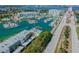 An aerial view showcases a marina with an array of boats docked near waterfront condominiums and the nearby causeway at 269 Madeira Cir, Tierra Verde, FL 33715