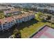 Aerial view showcasing townhouses, tennis courts, and lush green spaces at 269 Madeira Cir, Tierra Verde, FL 33715