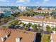 Aerial view shows townhouses, tennis courts, with water and city views at 269 Madeira Cir, Tierra Verde, FL 33715