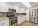Updated kitchen featuring stainless steel appliances, granite counters, subway tile backsplash, and white cabinetry at 269 Madeira Cir, Tierra Verde, FL 33715