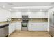Modern kitchen featuring white cabinetry, stainless steel appliances, and ample counter space for convenient meal preparation at 269 Madeira Cir, Tierra Verde, FL 33715