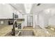Well-lit kitchen with stainless steel appliances, white cabinets, granite countertops, and a stylish backsplash at 269 Madeira Cir, Tierra Verde, FL 33715