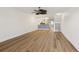 Open-concept living room showcasing wood floors, a ceiling fan, and a view into the adjacent kitchen space at 269 Madeira Cir, Tierra Verde, FL 33715