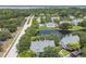 Community aerial view showcasing a lake, pool, nearby road and surrounding lush greenery and condominiums at 3261 Haviland Ct # 303, Palm Harbor, FL 34684