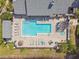 Aerial view of the community pool features a sun-soaked lounge area, spa, and lush greenery, perfect for relaxation at 3261 Haviland Ct # 303, Palm Harbor, FL 34684