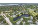 Aerial view of the neighborhood, highlighting a large pond with a pool surrounded by mature landscaping and trees at 3261 Haviland Ct # 303, Palm Harbor, FL 34684
