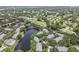 Aerial view showcasing a tranquil lake surrounded by condos, lush trees, and a beautifully landscaped community at 3261 Haviland Ct # 303, Palm Harbor, FL 34684