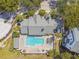 Aerial view showcases a refreshing pool with a spa and lounge chairs; lush greenery surrounds the property at 3261 Haviland Ct # 303, Palm Harbor, FL 34684