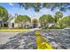 Exterior of clubhouse with mature trees and manicured landscaping at 3261 Haviland Ct # 303, Palm Harbor, FL 34684