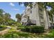 Condo exterior featuring mature trees, manicured lawn, and sidewalk at 3261 Haviland Ct # 303, Palm Harbor, FL 34684