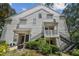 Exterior of white condo, with black staircases and well-maintained landscaping at 3261 Haviland Ct # 303, Palm Harbor, FL 34684