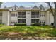 White condo featuring screened balconies, neat green lawn, and well-maintained shrubbery at 3261 Haviland Ct # 303, Palm Harbor, FL 34684