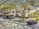 Exterior view of the building with covered parking and a well landscaped yard and second story balconies at 3261 Haviland Ct # 303, Palm Harbor, FL 34684