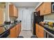 Well-lit kitchen featuring wood cabinets, tile floor, granite counters, and stainless steel appliances at 3261 Haviland Ct # 303, Palm Harbor, FL 34684