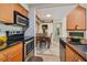 Open kitchen view into dining area featuring tile floors, stainless steel appliances, and wood cabinets at 3261 Haviland Ct # 303, Palm Harbor, FL 34684