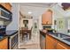 Open kitchen view into living and dining area featuring tile floors, stainless steel appliances, and wood cabinets at 3261 Haviland Ct # 303, Palm Harbor, FL 34684