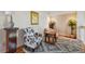 Bright loft area featuring stylish floral armchairs, wooden accents, a patterned rug, and decorative plants at 3261 Haviland Ct # 303, Palm Harbor, FL 34684