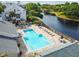 Community pool surrounded by lounge chairs and well maintained landscaping at 3261 Haviland Ct # 303, Palm Harbor, FL 34684