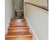 Hardwood stairs with white walls and a glimpse of a living room at 3261 Haviland Ct # 303, Palm Harbor, FL 34684