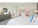 Bedroom with bed featuring white textured comforter, dresser, and multiple entry points at 32708 Winterwood Blvd, Wesley Chapel, FL 33543